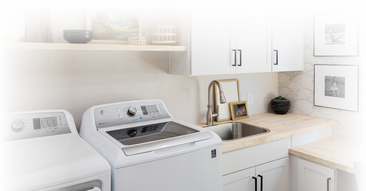 White laundry room with washer, dryer, sink, and cabinets