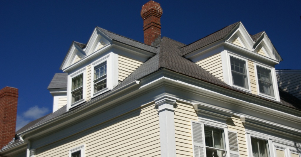 Three-story home with detailed trim and multiple dormer windows