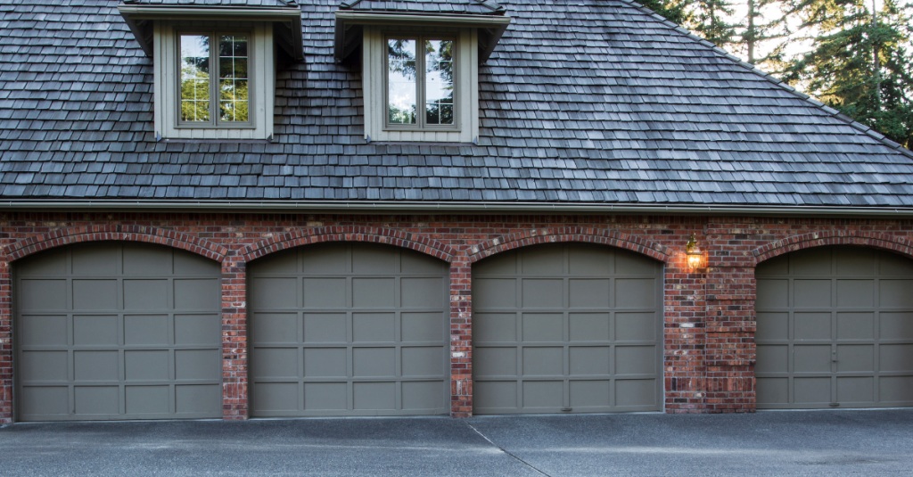 Brick garage addition with four matching arched doors and dormer windows