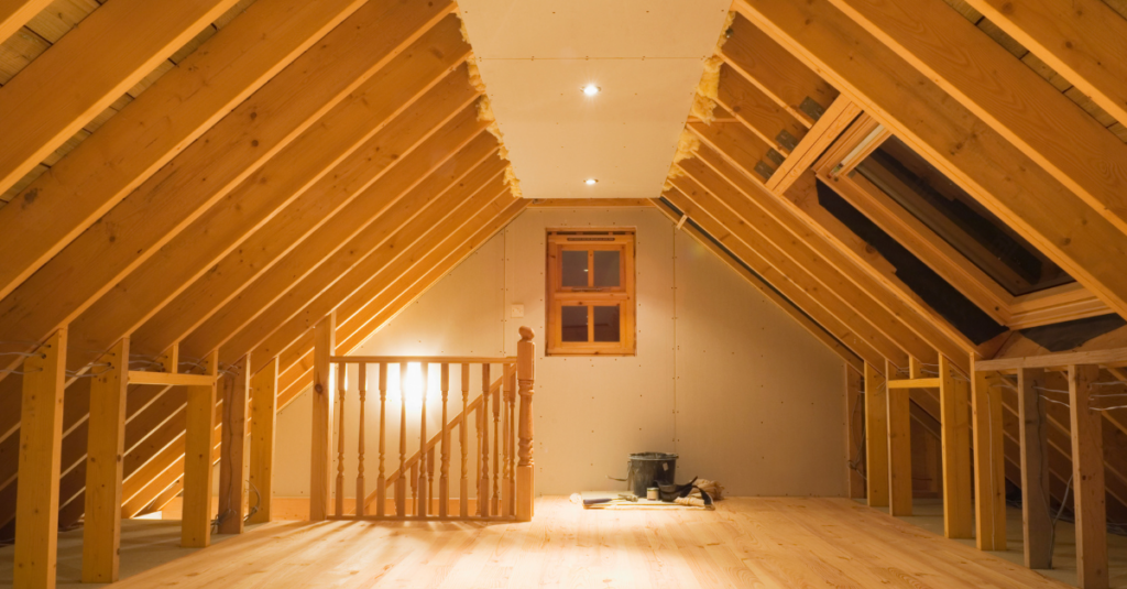 Unfinished attic with exposed rafters, plywood floor, back window, skylight, and railing.