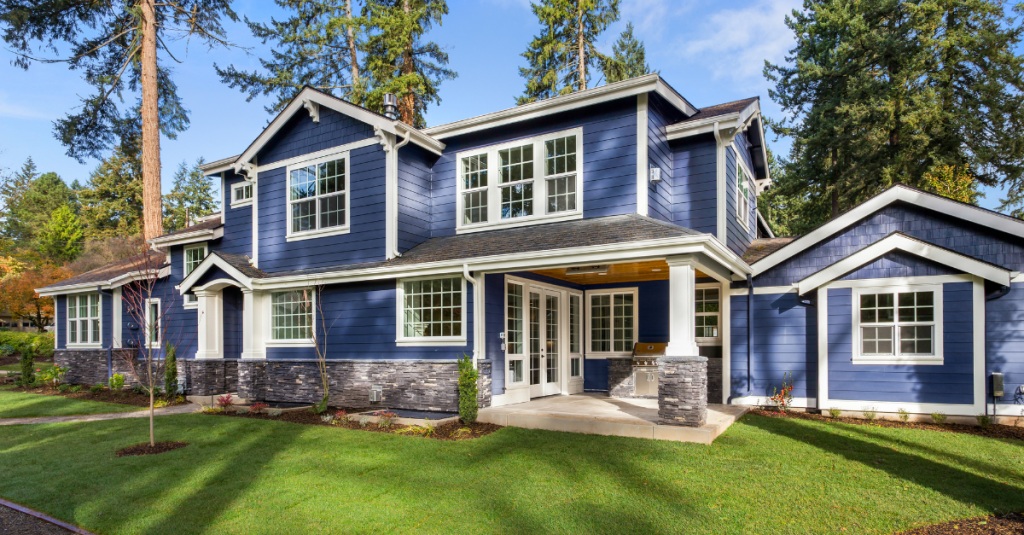Blue two-story home with a seamlessly integrated home extension and matching siding